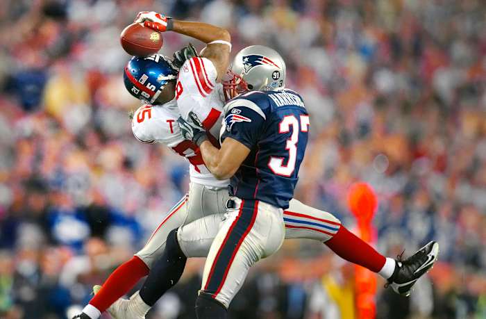 David Tyree catches a pass as a Patriots defender grabs him to tackle